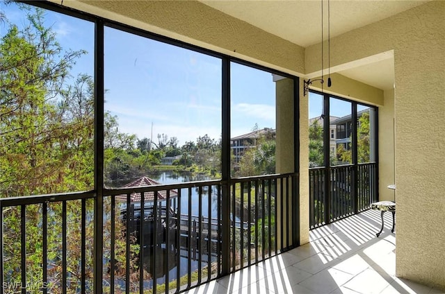 unfurnished sunroom featuring a water view