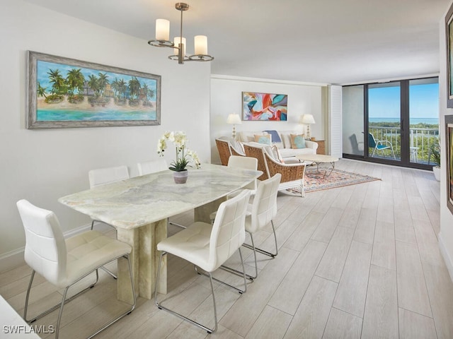 dining area featuring a chandelier, expansive windows, and light hardwood / wood-style floors