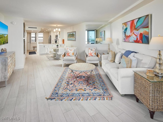 living room with a chandelier and light wood-type flooring