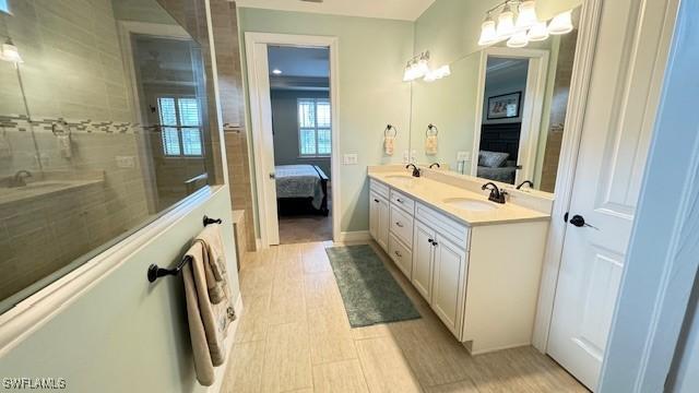 bathroom with a tile shower, vanity, a notable chandelier, and hardwood / wood-style floors