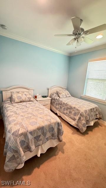 carpeted bedroom with ceiling fan and crown molding