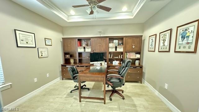 home office featuring ceiling fan, ornamental molding, and a tray ceiling