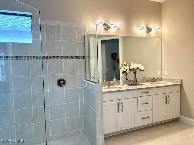 bathroom with tile patterned floors, vanity, and a tile shower