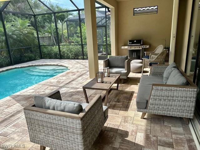 view of pool featuring a patio area, a grill, glass enclosure, and an outdoor hangout area