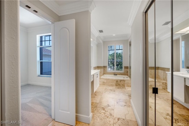 bathroom featuring vanity, crown molding, and tiled tub