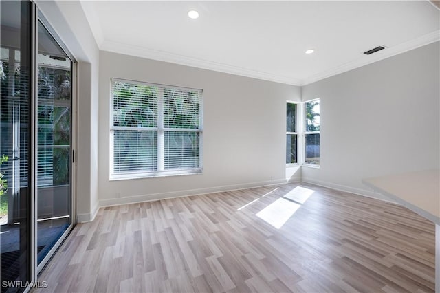 spare room featuring light wood-type flooring and ornamental molding