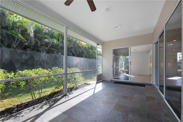 unfurnished sunroom featuring ceiling fan