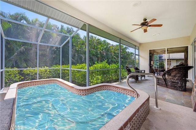 unfurnished sunroom featuring ceiling fan and a hot tub