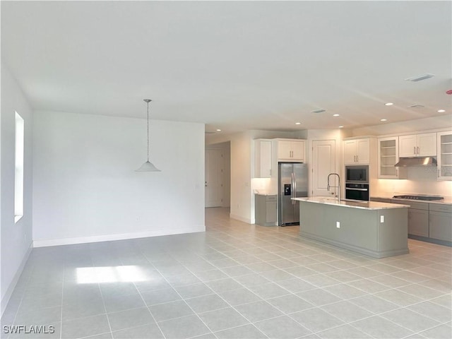 kitchen with white cabinetry, decorative light fixtures, light tile patterned floors, appliances with stainless steel finishes, and a kitchen island with sink