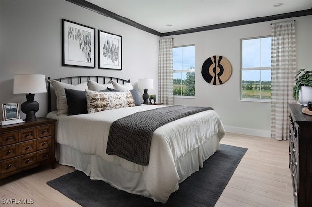 bedroom with crown molding and light hardwood / wood-style flooring