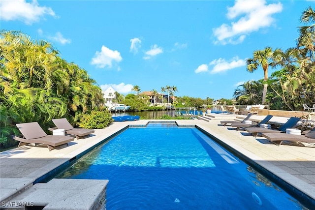 view of swimming pool featuring a water view and a patio