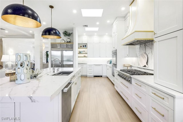 kitchen featuring sink, hanging light fixtures, stainless steel appliances, a large island, and white cabinets