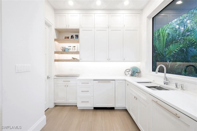 kitchen featuring light wood-type flooring, sink, and white cabinets