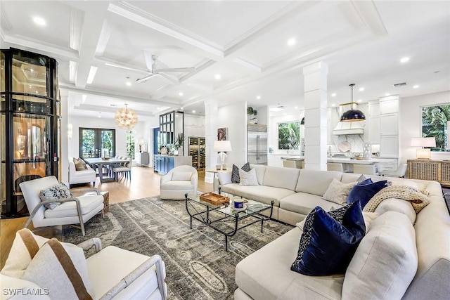 living room with ornate columns, coffered ceiling, light wood-type flooring, and beam ceiling