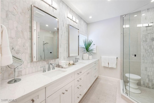 bathroom featuring vanity, a shower with shower door, and toilet