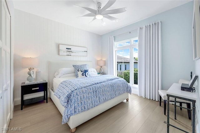 bedroom with light hardwood / wood-style flooring, ceiling fan, and access to outside