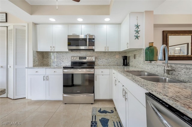 kitchen featuring backsplash, white cabinetry, sink, and appliances with stainless steel finishes