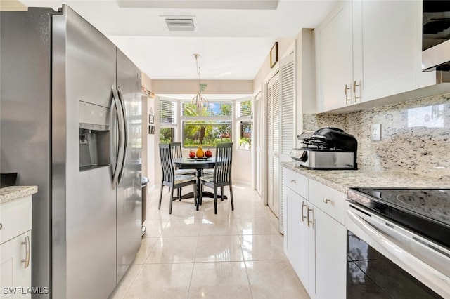 kitchen with appliances with stainless steel finishes, tasteful backsplash, decorative light fixtures, white cabinets, and light tile patterned flooring