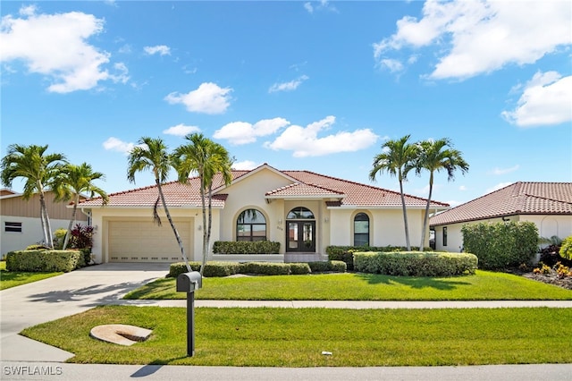 mediterranean / spanish home with a front yard and a garage