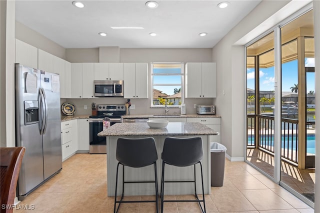 kitchen with plenty of natural light, white cabinetry, and stainless steel appliances