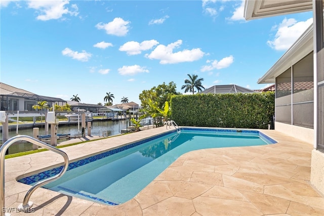 view of swimming pool featuring a boat dock, a patio area, and a water view