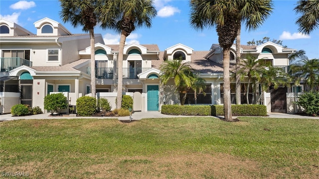 view of front facade featuring a front yard and a balcony