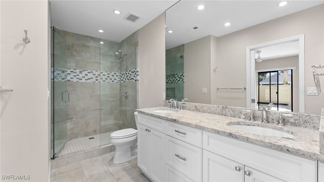 bathroom featuring tile patterned floors, a shower with door, vanity, and toilet