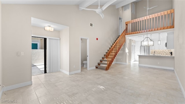 unfurnished living room with beam ceiling, high vaulted ceiling, and ceiling fan