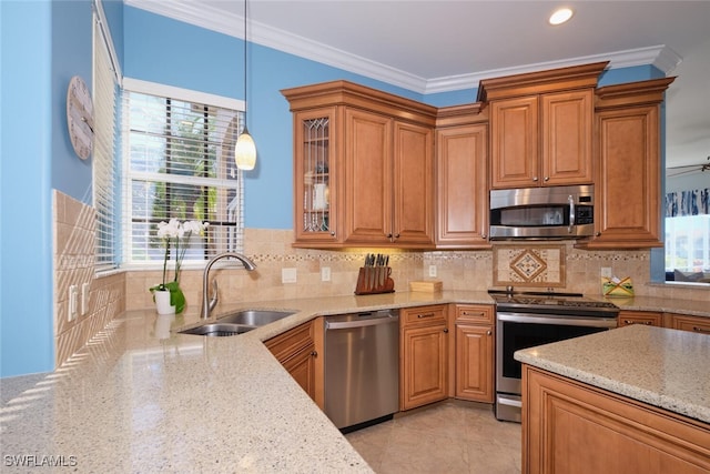 kitchen featuring appliances with stainless steel finishes, a wealth of natural light, pendant lighting, and sink