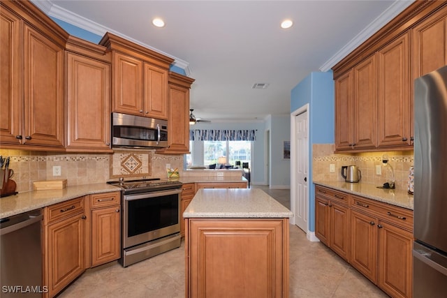 kitchen with backsplash, crown molding, a center island, and stainless steel appliances