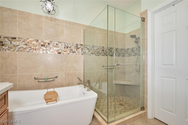 bathroom featuring plus walk in shower, tile patterned flooring, and vanity