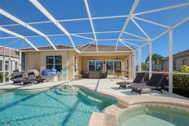 view of swimming pool featuring glass enclosure, ceiling fan, and a patio area