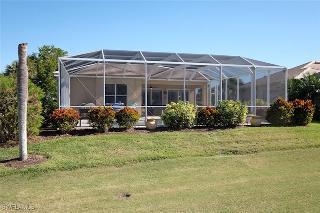 back of property with a lanai and a yard