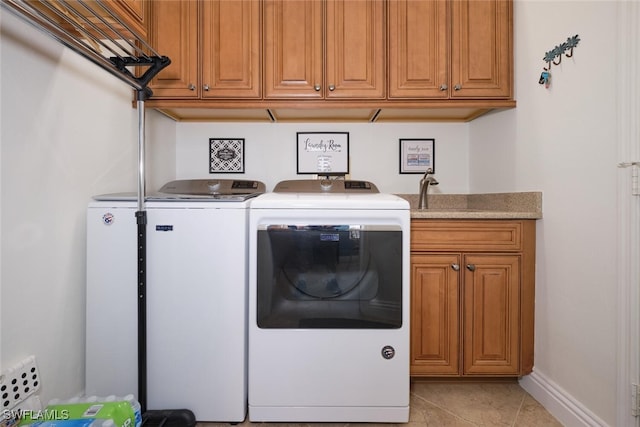 clothes washing area featuring light tile patterned flooring, cabinets, sink, and washing machine and clothes dryer