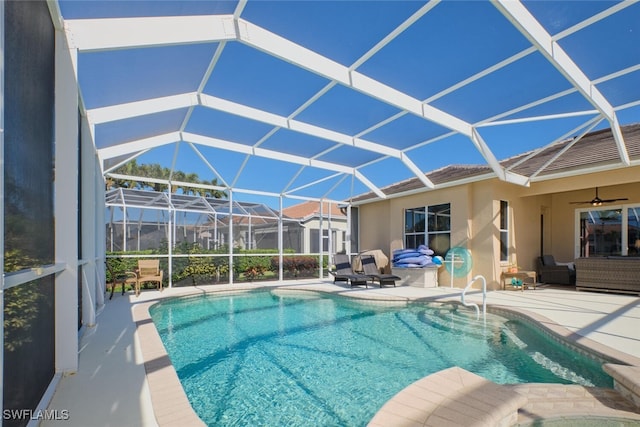 view of pool featuring a lanai, ceiling fan, a patio area, and an outdoor hangout area