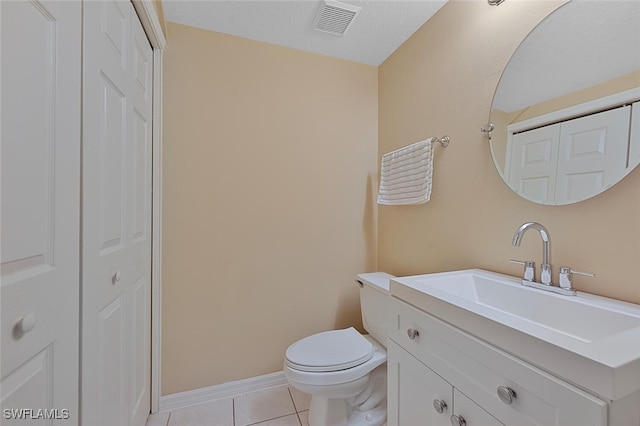 bathroom with tile patterned floors, vanity, toilet, and a textured ceiling