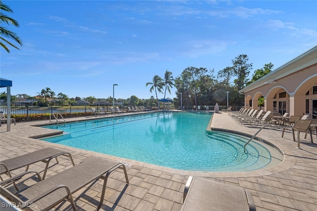 view of swimming pool featuring a patio area and a water view