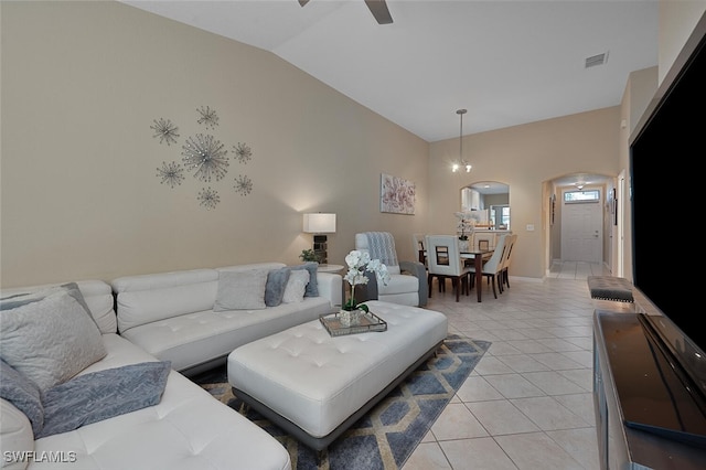 tiled living room featuring high vaulted ceiling