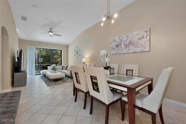 tiled dining area featuring ceiling fan with notable chandelier and vaulted ceiling