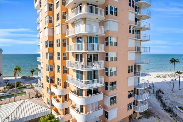 view of property with a water view and a view of the beach