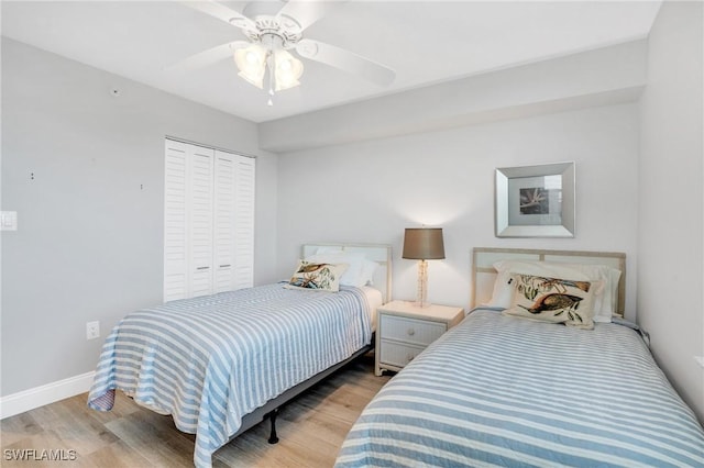 bedroom with light wood-style floors, a closet, ceiling fan, and baseboards