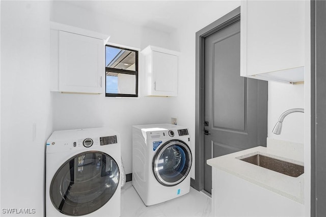 laundry room featuring washer and clothes dryer, sink, and cabinets