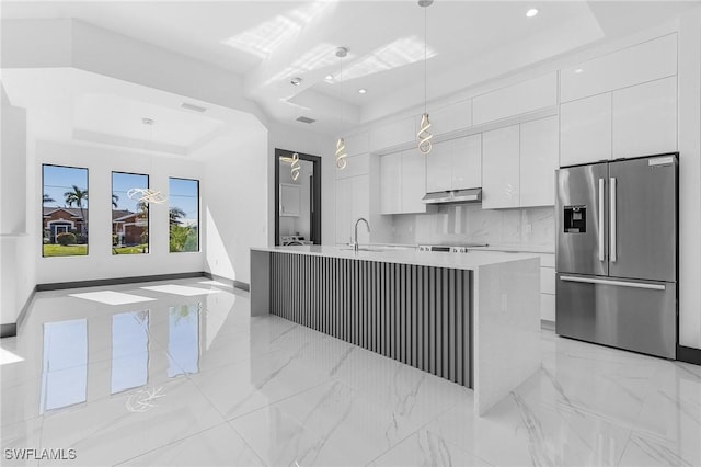 kitchen with a tray ceiling, white cabinetry, pendant lighting, and stainless steel refrigerator with ice dispenser