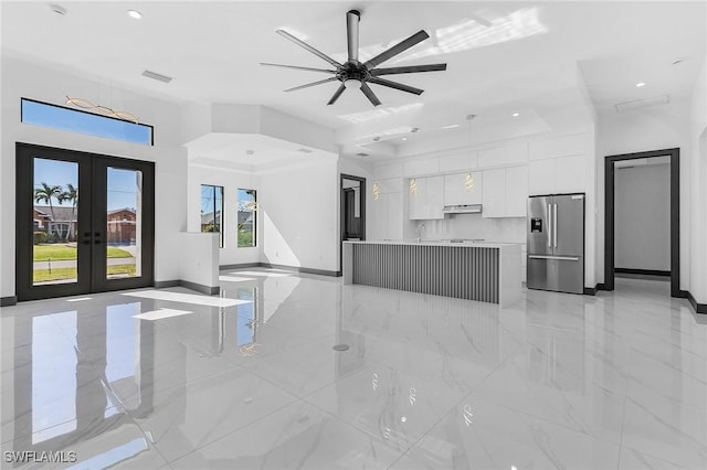 unfurnished living room with ceiling fan, french doors, and sink