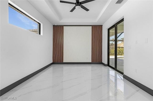 2123 SW 52nd Ter, Cape Coral, FL 33914 - empty room with marble tiled floors, a tray ceiling, and ceiling fan