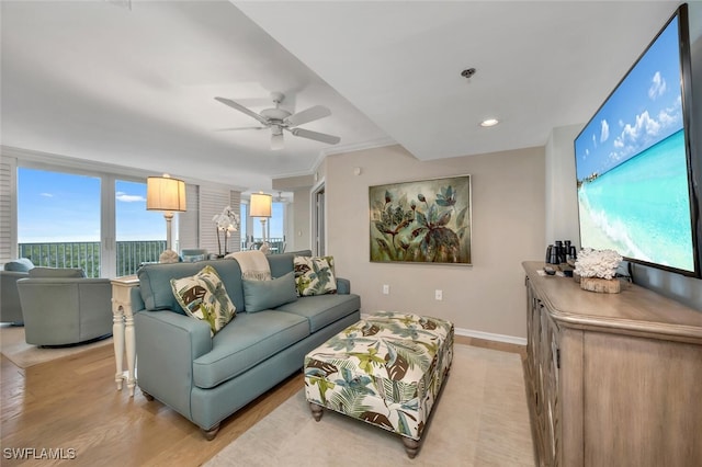 living room with light hardwood / wood-style flooring, ceiling fan, and crown molding