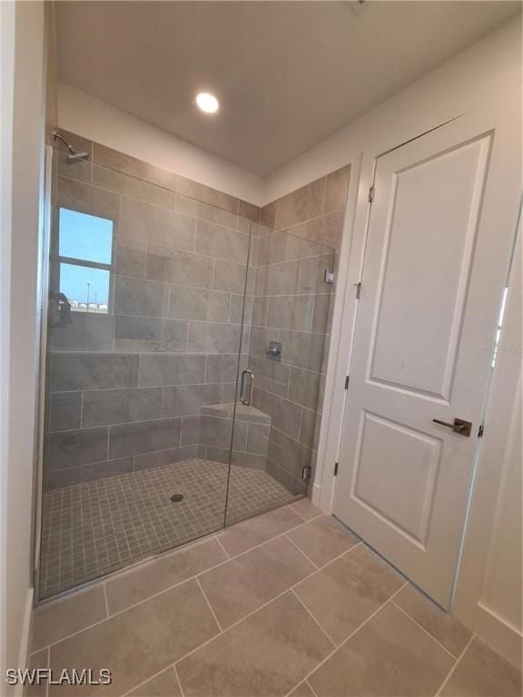 bathroom featuring tile patterned floors and a shower with shower door