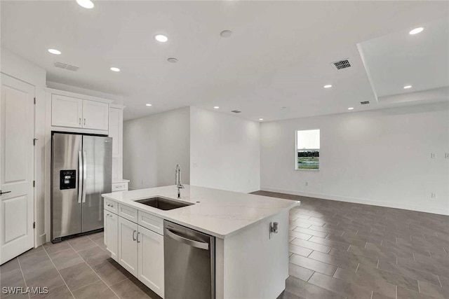 kitchen with white cabinetry, sink, stainless steel appliances, and a center island with sink