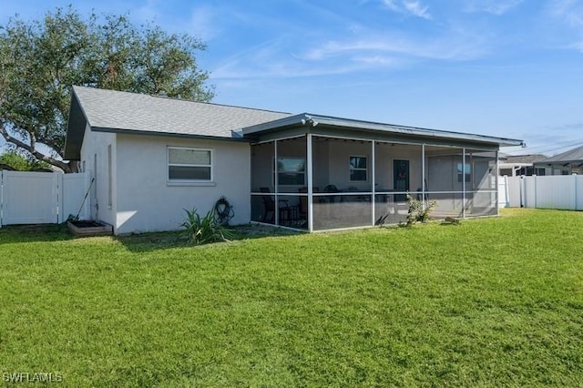 rear view of house with a sunroom and a yard