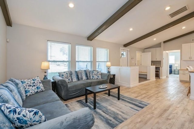 living room featuring lofted ceiling with beams and light hardwood / wood-style floors